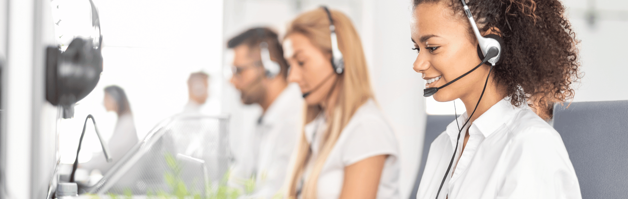 Customer service agents wearing headsets work at their desks in a bright call center.ensures clear communication with customers.